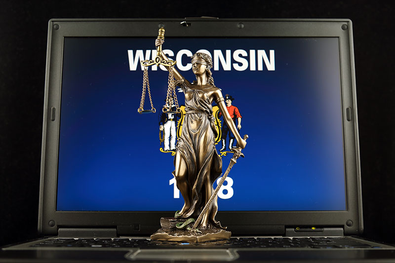 Symbol of law and justice with Wisconsin State Flag on laptop. 