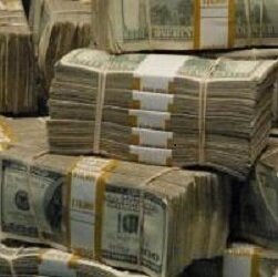 Bundles of $100 bills worth $10,000 stacked on top of each other.