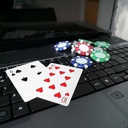 The ten of hearts and six of spades along with some poker chips on a laptop computer.