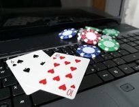 The ten of hearts and six of spades along with some poker chips on a laptop computer.