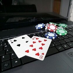 The ten of hearts and six of spades along with some poker chips on a laptop computer.