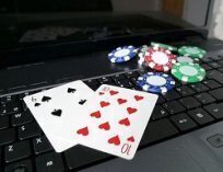 The ten of hearts and six of spades along with some poker chips on a laptop computer.