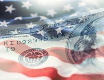 American Flag with ripples as if blowing in the wind with a watermark of an American $100 banknote.