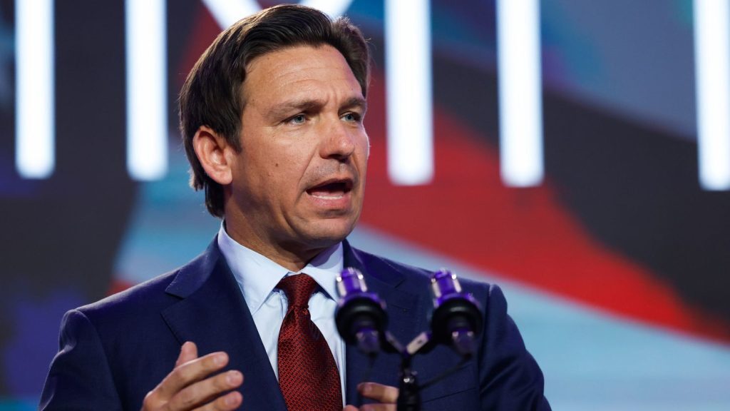 Ron Desantis speaking into a mic to a crowd