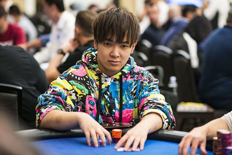 Masato Yokosawa handling chips in a colored sweater