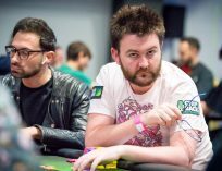 David Lappin playing poker and pointing to his shirt