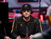Phil Hellmuth with sunglasses on and headphones on playing poker