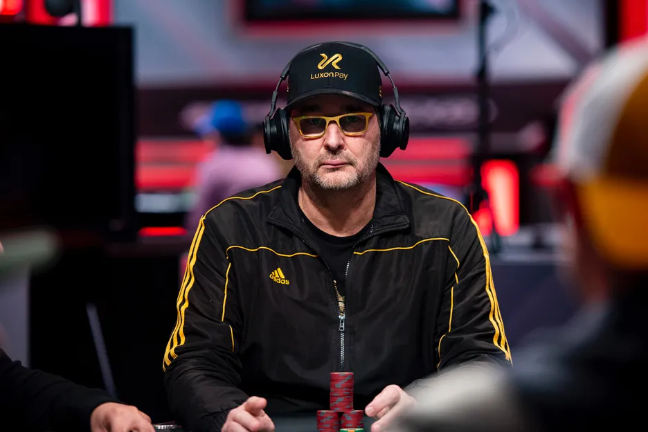 Phil Hellmuth with sunglasses on and headphones on playing poker