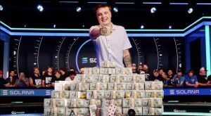 Lucas Jumalon celebrates after winning the 2026 WSOP Main Event, posing behind stacks of prize money while holding the championship bracelet.